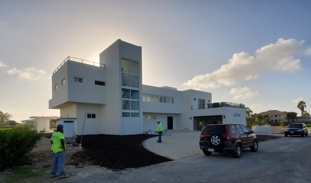 Modern house with workers outside
